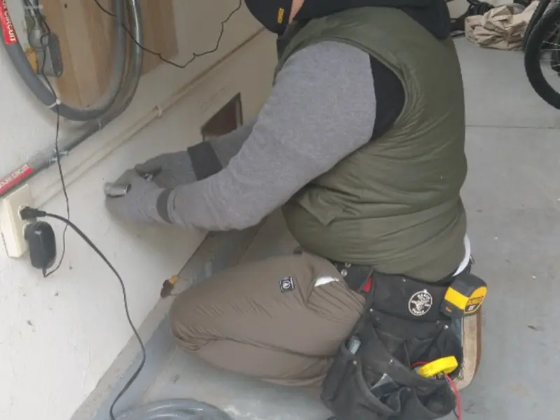 Electrician performing outlet wiring in a Woodward garage